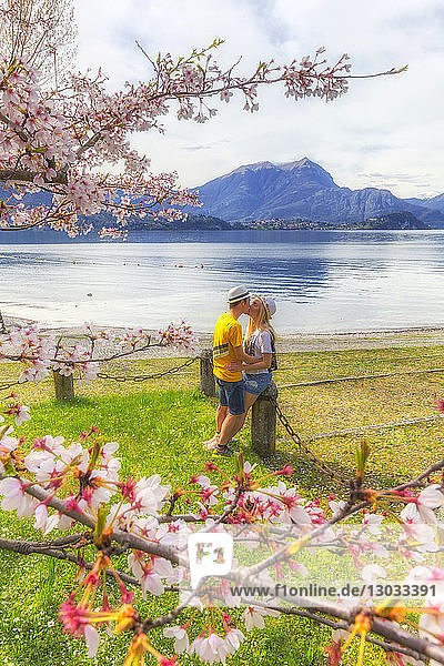 Touristenpaar küsst sich vor dem See  Lierna  Provinz Lecco  Comer See  Italienische Seen  Lombardei  Italien