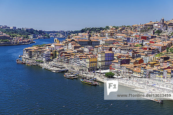 The Douro River banks with waterfront houses and boats seen from Dom Luis I Bridge  Porto  Portugal