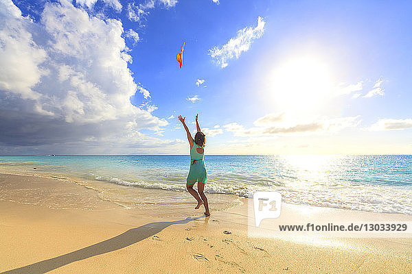Frau am Strand wirft den Hut in die Luft  Ffryes Beach  Antigua  Antigua und Barbuda  Leeward Islands  Westindische Inseln  Karibik