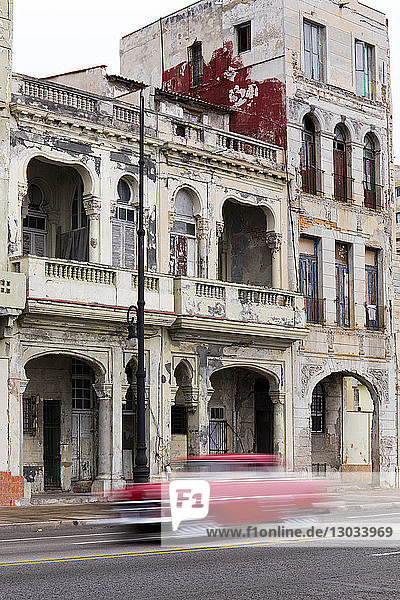 Unscharfer roter Oldtimer auf dem Malecon  Havanna  Kuba  Westindien  Karibik