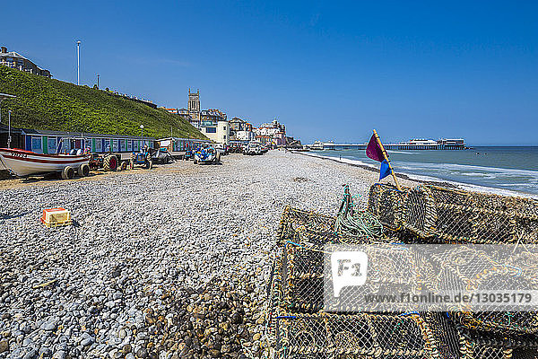 View of fishing baskets on the beach and Parish Church overlooking pier on a summer day  Cromer  Norfolk  England  United Kingdom
