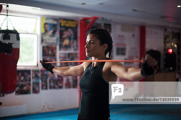 Female boxer doing stretching exercise in gym