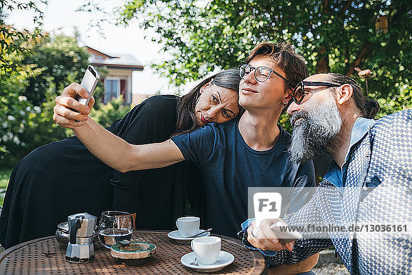 Eine Familie  die sich beim Kaffee auf der Terrasse selbstständig macht
