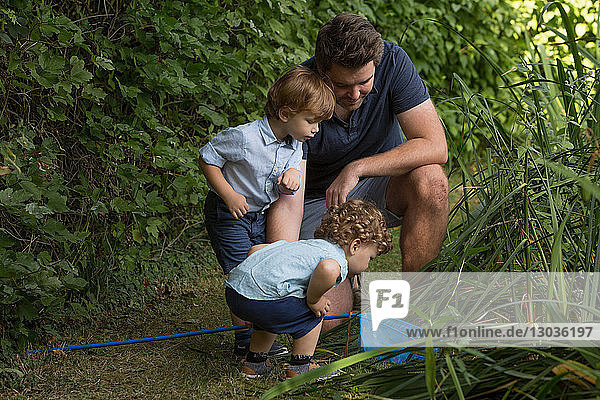 Vater und Kinder schauen im Fischernetz