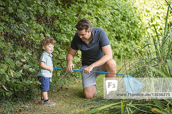Vater und Kind mit Fischernetz im Park