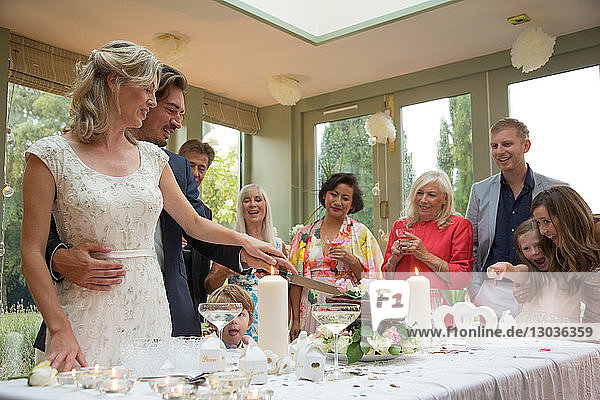 Newlyweds cutting wedding cake at reception