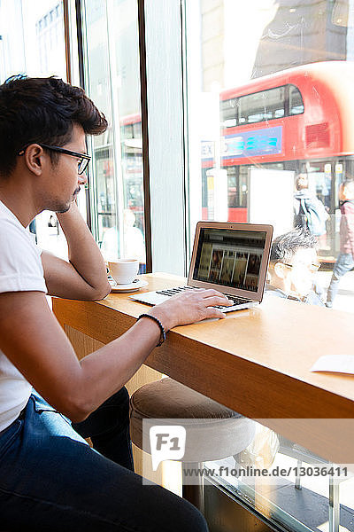 Mann benutzt Laptop im Café