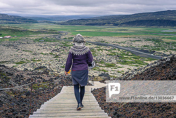 Frau beim Spaziergang um den Vulkan Grabrok  Island