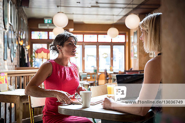 Frauen beim Brainstorming von Geschäftsideen im Restaurant