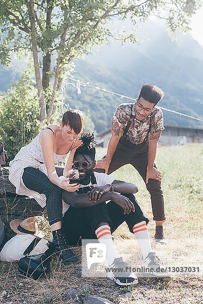 Drei junge erwachsene Wanderer vor Ort mit Smartphone im Blick  Primaluna  Trentino-Südtirol  Italien