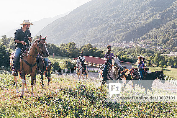 Junge Erwachsene reiten Pferde in ländlicher Landschaft  Primaluna  Trentino-Südtirol  Italien