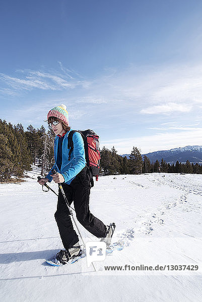 Side view shot of a woman snowshoeing in winter