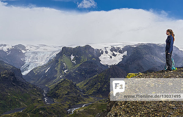 Side view shot of a single female hiker looking down to theâ€ Thorsmorkâ€ valley â€ Sudurland  Iceland