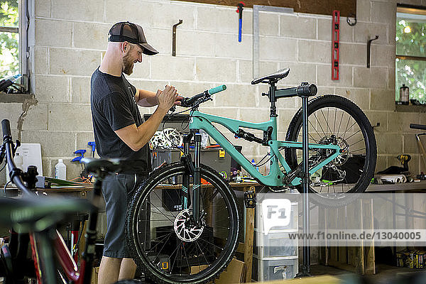 Mechanic repairing mountain bike in bicycle shop