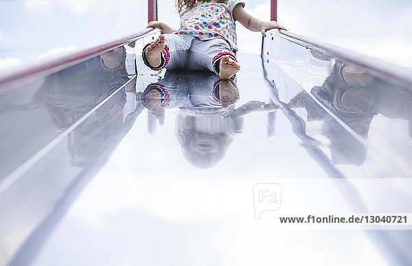 Niederer Teil eines Mädchens spielt auf einer Rutsche auf einem Spielplatz