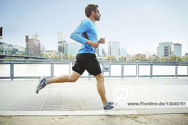 Male athlete jogging on promenade in city
