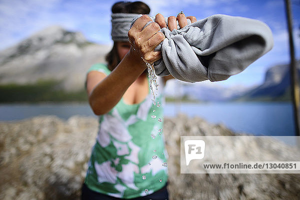 Wanderin quetscht Jacke  während sie im Banff-Nationalpark am Ufer steht