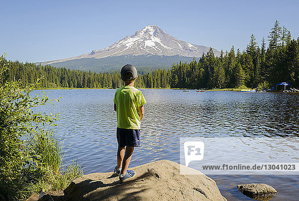 Full length of boy looking at view while standing on rock by Trillium Lake