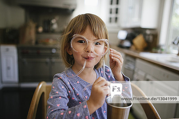 Portrait of cute girl wearing novelty glasses at home