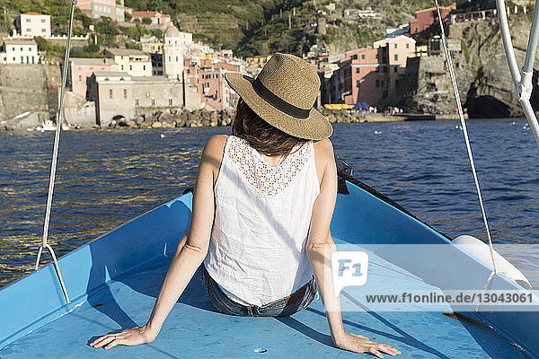 Rear view of woman traveling in boat on sea at Vernazza