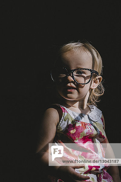 Porträt eines süßen Mädchens mit Brille in der Dunkelkammer