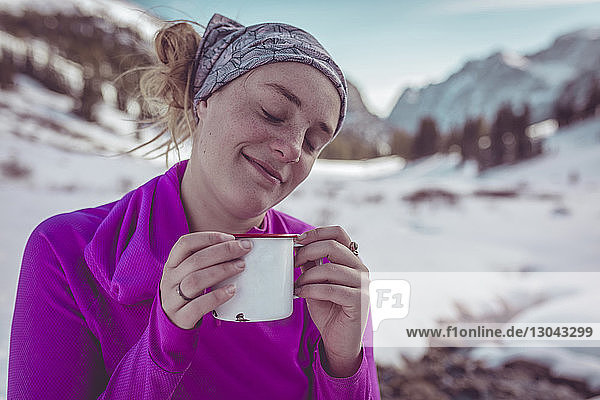 Frau trinkt im Grand-Teton-Nationalpark im Winter beim Entspannen