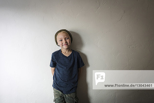Porträt eines Jungen  der zu Hause an der Wand steht