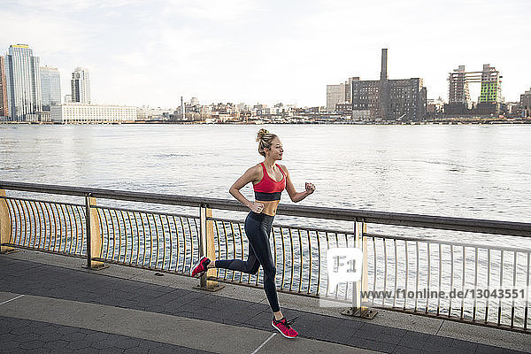 Weibliche Athletin läuft auf der Promenade am East River