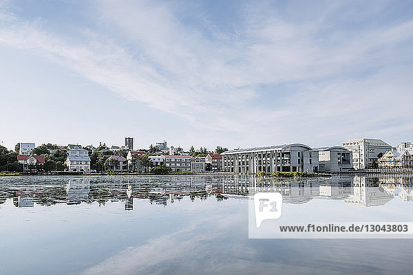 Häuser am See gegen bewölkten Himmel