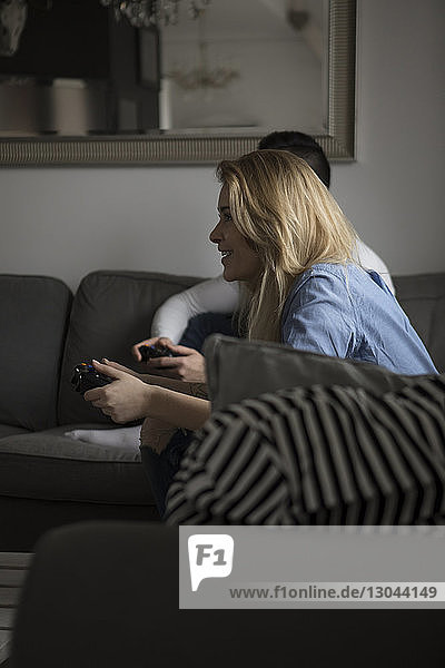 Glückliches Paar spielt zu Hause auf dem Sofa ein Videospiel