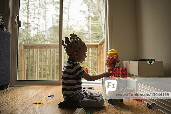 Seitenansicht eines Jungen  der zu Hause mit Spielzeugklötzen spielt
