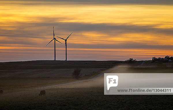 Scherenschnitt Windturbinen auf dem Feld bei Sonnenuntergang