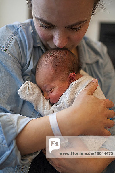 Mother embracing newborn baby at home