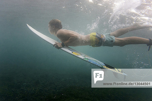 Seitenansicht eines Mannes beim Unterwasser-Surfen