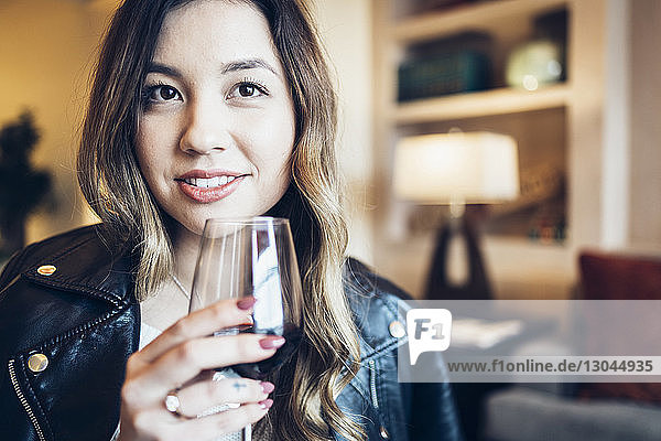 Porträt einer selbstbewussten Geschäftsfrau mit Weinglas im Hotel