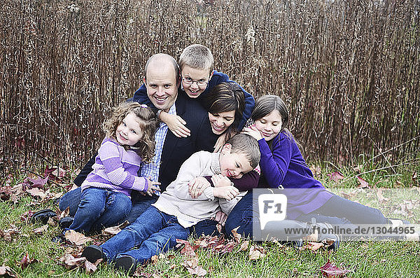 Glückliche Familie sitzt im Herbst auf dem Feld