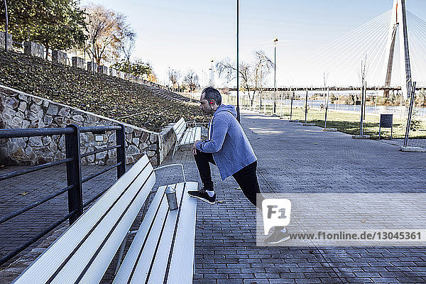 Side view of man exercising on bench at park