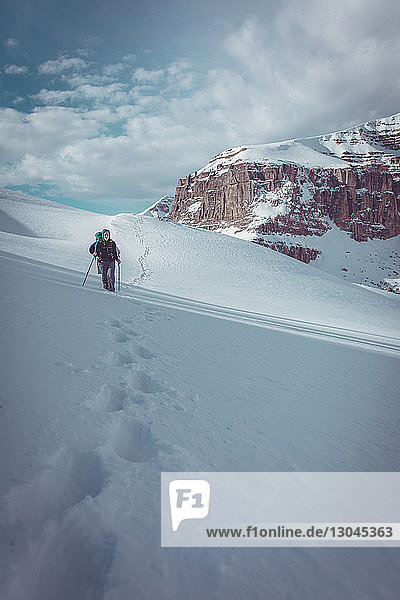 Wanderin in voller Länge auf schneebedecktem Feld