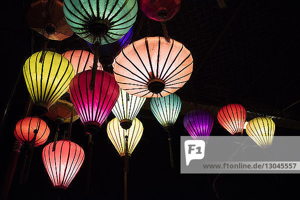 Low angle view of illuminated colorful lanterns in darkroom