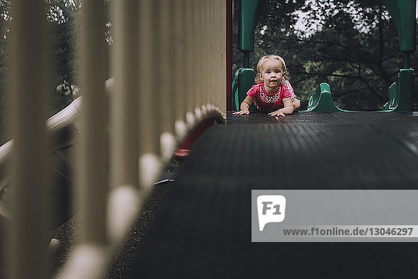 Porträt eines kleinen Mädchens auf einer Rutsche auf einem Spielplatz