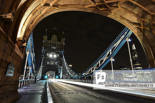 Lichtspuren auf der Tower Bridge in der beleuchteten Stadt gegen den nächtlichen Himmel