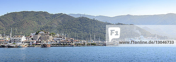 Panoramablick auf Boote und Kreuzfahrtschiff im Hafen vor den Bergen