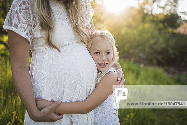 Mittelsektion einer schwangeren Mutter mit Tochter im Park