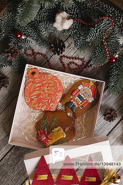 Hochwinkelansicht von Keksen mit Weihnachtsdekoration auf Holztisch