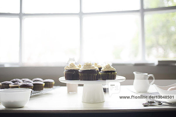 Cupcakes auf Kuchenstand vor Fenster