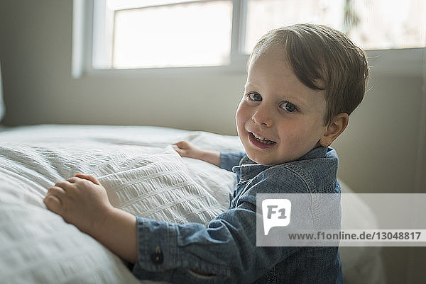 Seitenansicht Porträt eines süßen Jungen  der im Schlafzimmer lächelt