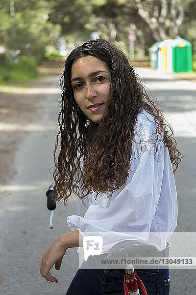 Porträt einer Frau mit Fahrrad auf der Strasse