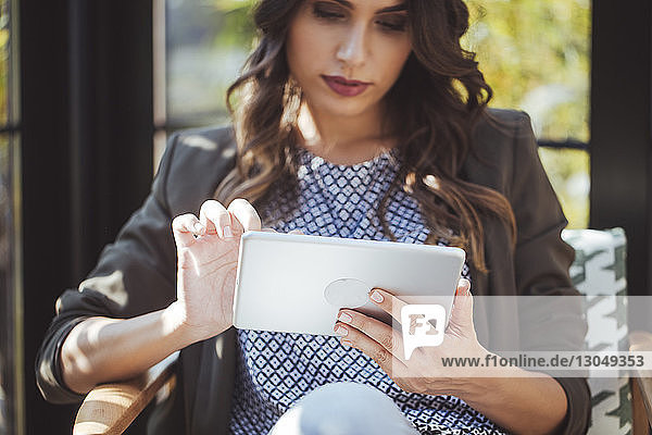 Frau benutzt Tablet-Computer im Café