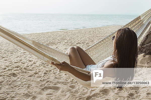 Frau entspannt sich auf Hängematte am Strand