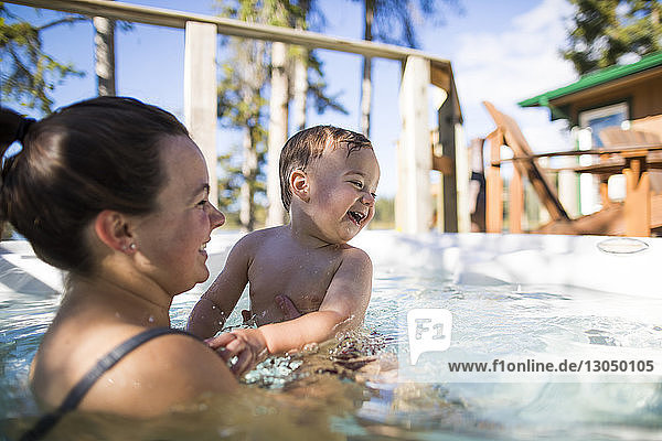 Happy mother and son swimming in pool